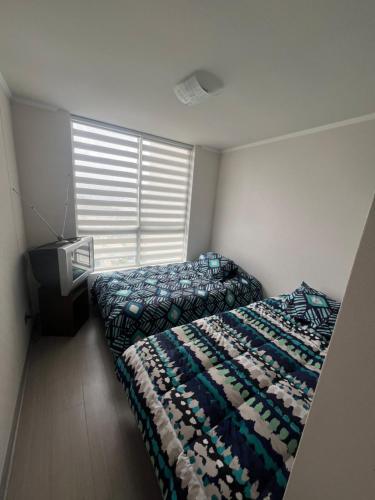 een slaapkamer met 2 bedden en een raam bij Sol in Valparaíso