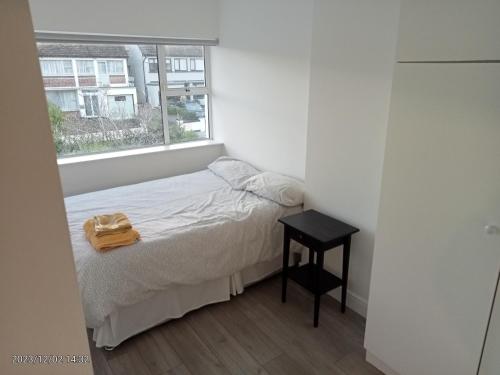 ein kleines Schlafzimmer mit einem Bett und einem Fenster in der Unterkunft Home away from home in Dublin