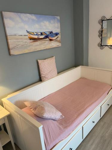 a bed in a room with a painting on the wall at T H E BERLIN Studios and Suites in Nea Vrasna