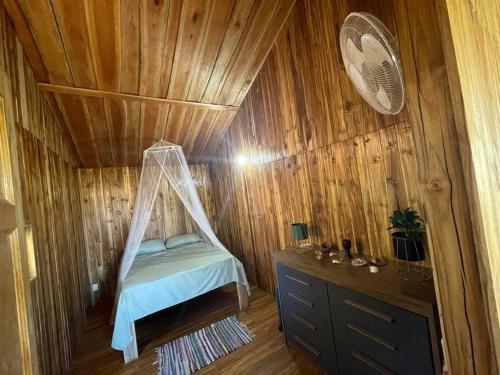 sypialnia z łóżkiem w drewnianej ścianie w obiekcie Petit paradis w mieście Montaña Grande