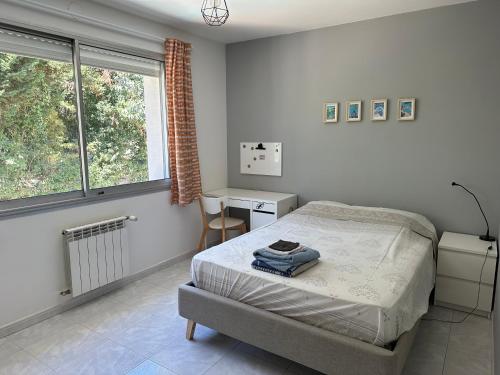 une chambre avec un lit, un bureau et une fenêtre dans l'établissement Maison au calme au cœur du village de Mazargues - 7 personnes - Piscine, à Marseille