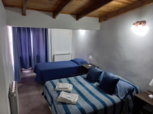 1 dormitorio con 2 camas y sábanas azules en La Escondida en Ushuaia