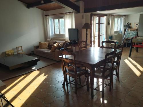 un salon avec une table et des chaises en bois dans l'établissement Longère charentaise familiale., à La Tremblade