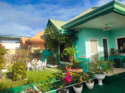 a house with a garden with chairs and flowers at Private 2-Floors Bedroom near DVO Airport in Davao City