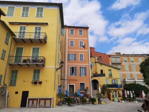a row of colorful buildings in a street at Prato Home - apartment near the beach in Menton in Menton