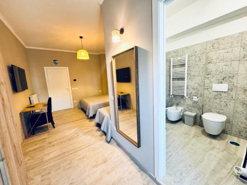 łazienka z lustrem i sypialnia z łóżkiem w obiekcie Doina Guest House w Rzymie