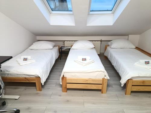 two twin beds in a room with skylights at Sleep In Center in Kraków