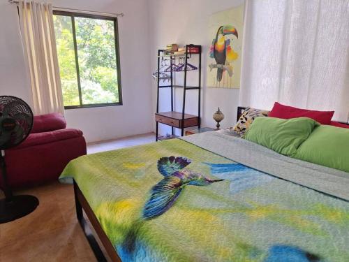 a bedroom with a bed with a bird painted on it at Casa sin Tiempo in Uvita