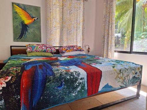 a bedroom with a colorful bed with a bird on it at Casa sin Tiempo in Uvita