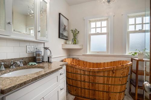 ein Badezimmer mit einem Waschbecken und einem Holzfass in der Unterkunft Maple Family Suite in Berkeley