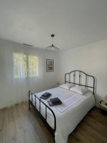 1 dormitorio con 1 cama grande y paredes blancas en Le Logis de Pomerol, en Pomerol