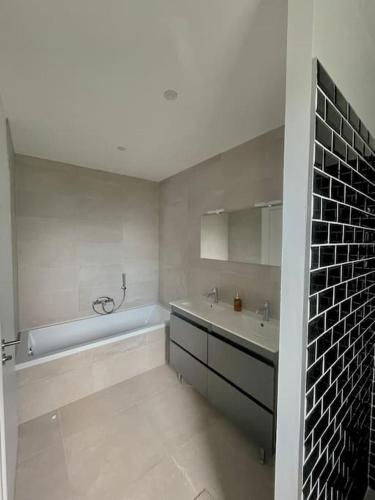 een witte badkamer met een bad en een wastafel bij Le Logis de Pomerol in Pomerol