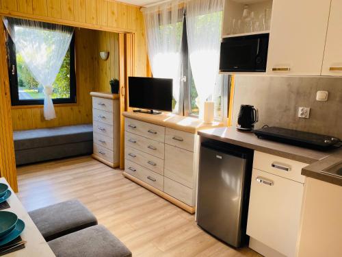 uma cozinha com armários brancos e uma bancada em Domki Letniskowe Jarek em Rowy