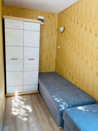 a small bedroom with a bed and a dresser at Domki Letniskowe Jarek in Rowy