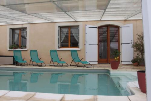 uma piscina com cadeiras ao lado de uma casa em Gites l’Olivier avec piscine em Vallon-Pont-dʼArc