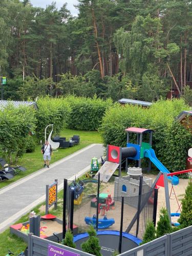 dziecko bawiące się na placu zabaw w parku w obiekcie Domki Letniskowe Jarek w Rowach