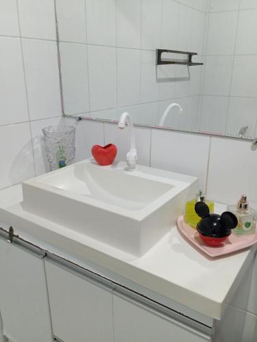 a white bathroom sink with a red heart on it at Cantinho acolhedor da Manu in Salvador