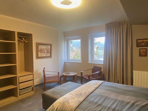 una camera da letto con un letto e due finestre di La Maison du cèdre a Dossenheim-sur-Zinsel