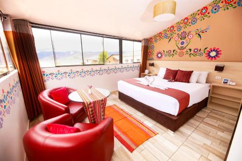 a hotel room with a bed and two chairs at Mayu Boutique Hotel in Cusco