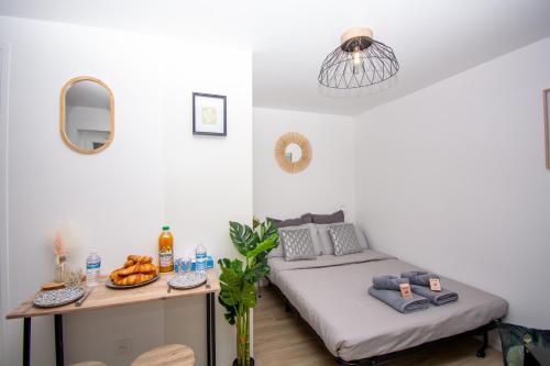 ein Schlafzimmer mit einem Bett und einem Tisch mit Obst darauf in der Unterkunft Studio rénové calme et cosy (10' Paris Pte d'Ivry) in Ivry-sur-Seine