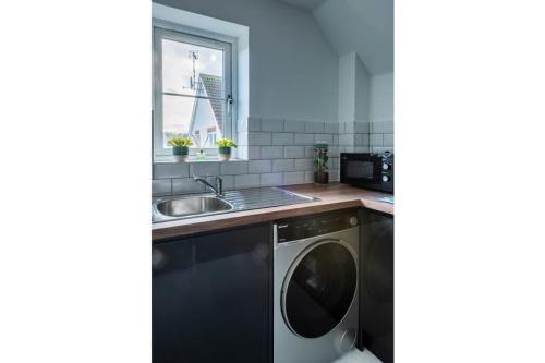 een keuken met een wasmachine en een wastafel bij Towpath Gardens Apartment (Free Parking and Central) in Swindon