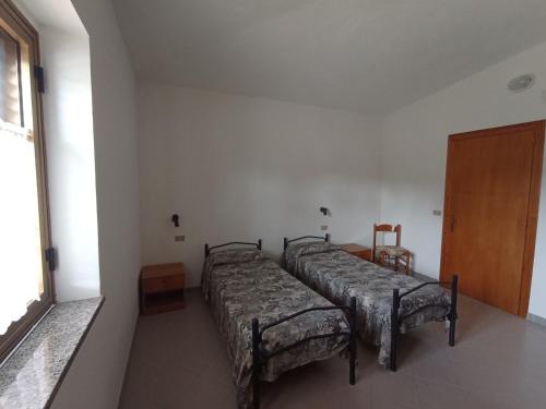 two beds in a room with a window at Appartamento Loiacono - Seaview appartaments in Ricadi