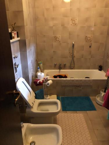 een badkamer met een toilet en een bad bij Bazzini House in Carnate
