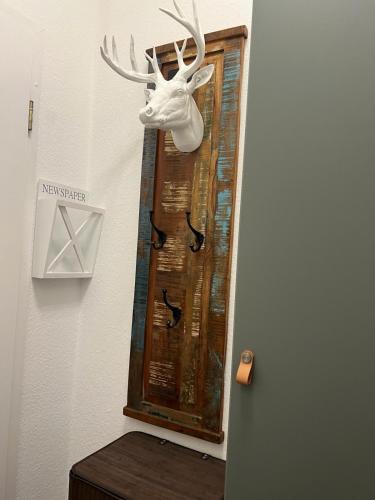 a mirror with a deer head on a wall at Laluna Modernes Wohnstudio mit Balkon im Herzen von Bad Rothenfelde in Bad Rothenfelde
