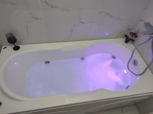 a white bath tub with a purple object in it at Amazing Apartments @ Monastiraki Subway Station in Athens