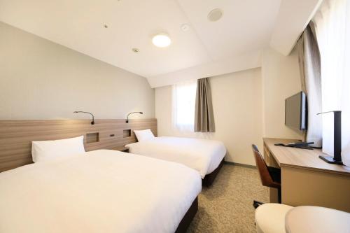 さいたま市にあるMarroad inn omiyaのベッド2台と机があるホテルの部屋