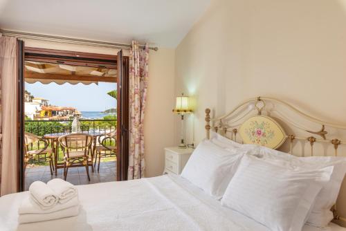 a bedroom with a bed and a balcony with a table at Angela Studios in Sivota