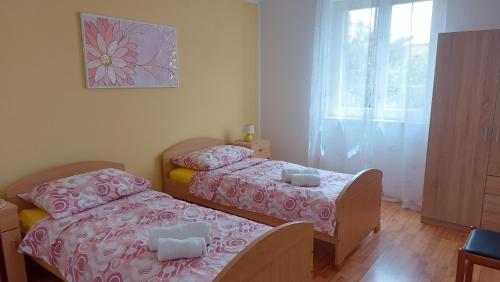 a bedroom with two beds and a window at Apartments Ines in Medulin