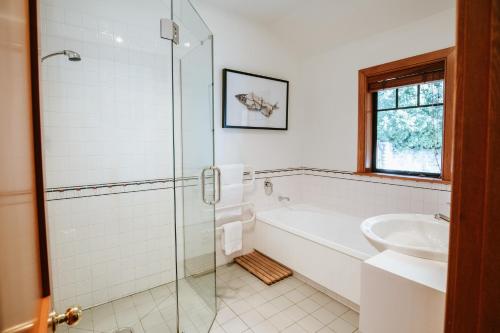 a bathroom with a shower and a tub and a sink at Bullock Creek Chalet - Sleeps 8 - Lake & Mountain Views - Private & Secluded in Wanaka