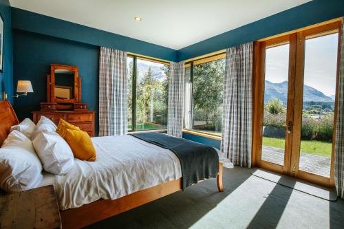 ワナカにあるBullock Creek Chalet - Sleeps 8 - Lake & Mountain Views - Private & Secludedのベッドと大きな窓のある寝室