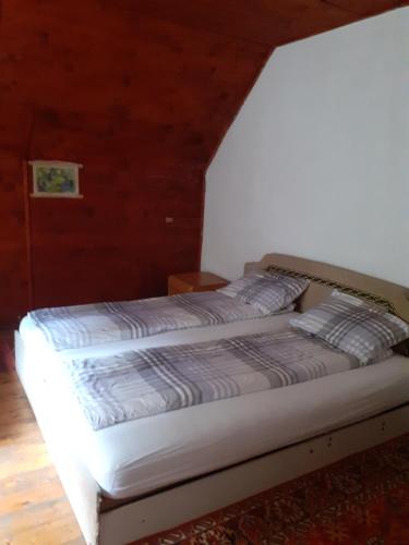1 cama con 2 almohadas en una habitación en Cabana Valea Stanciului Stefan, en Răchiţele
