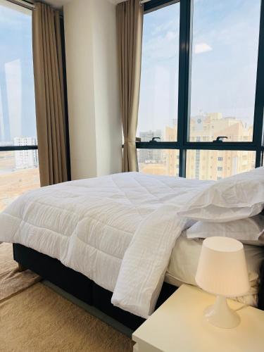 a bedroom with a large bed with a large window at Deluxe Flat in Muscat