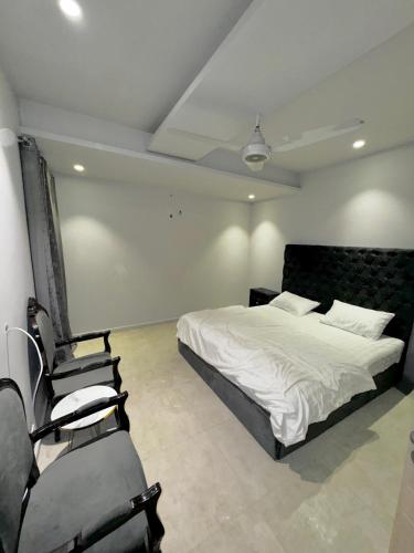 - une chambre avec un lit et une chaise dans l'établissement Essence Homes, à Islamabad