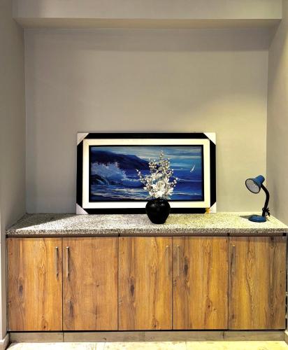 a tv sitting on top of a wooden entertainment center at Essence Homes in Islamabad