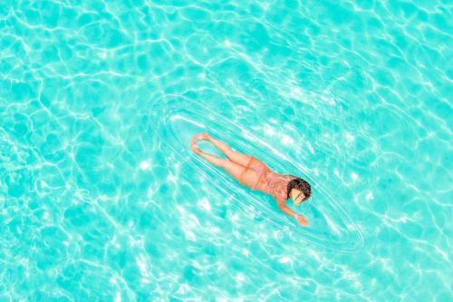 a man laying on a raft in the water at Evelin's On The Beach in Montego Bay