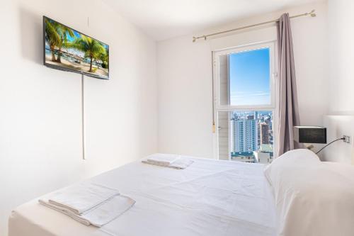een witte slaapkamer met een wit bed en een raam bij Tower San Remo 9-E Apartment Levante Beach in Benidorm