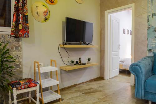 a living room with a tv and a blue couch at White Arrow Apartment in Bajina Bašta