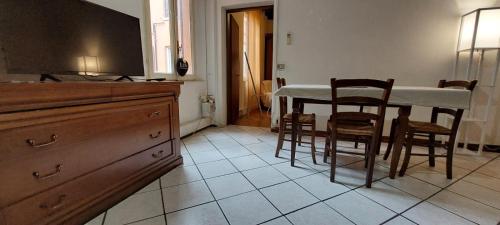 uma cozinha com uma mesa e algumas cadeiras e um balcão em La Sosta-appartamento a pochi passi dalla stazione em Módena
