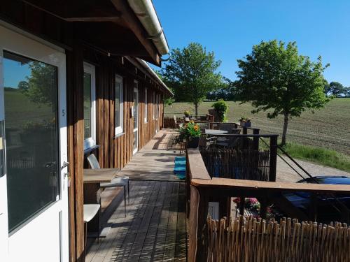 a wooden porch of a building with a table and benches at Billund countryside Appartement in Give