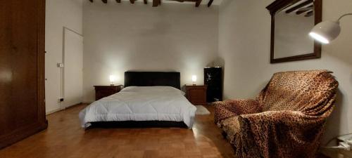 um quarto com uma cama e uma cadeira em La Sosta-appartamento a pochi passi dalla stazione em Módena