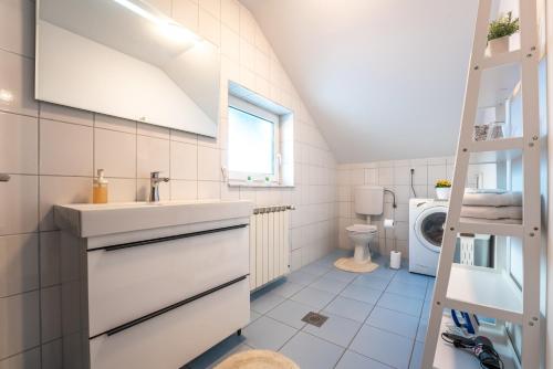 a bathroom with a sink and a washing machine at Apartment Premier in Bjelovar