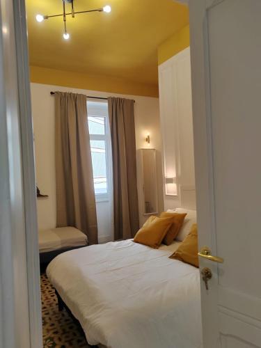 a bedroom with a bed with white sheets and yellow pillows at Gala Sardinia in Cagliari