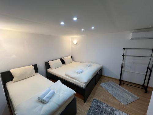 a room with two beds and a rug at Gray harmony rooms in Mostar