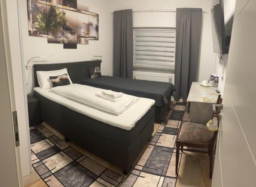 ザンクト・イングベルトにあるHotel Am Wildparkの小さなベッドルーム(ベッド1台、テーブル付)