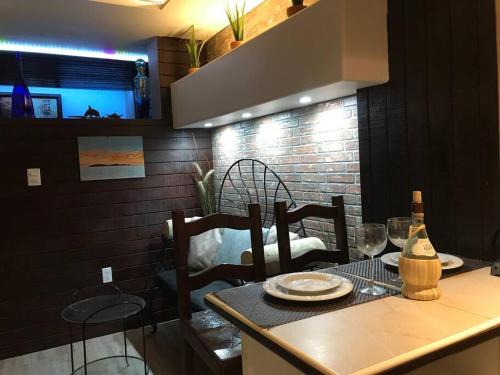 a dining room table with chairs and a table with wine glasses at Lovely 1 downtown studio in Rosarito