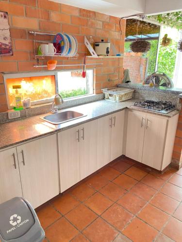 uma cozinha com um lavatório e uma parede de tijolos em Casa Vacacional Ciudadela Sol em San Jerónimo